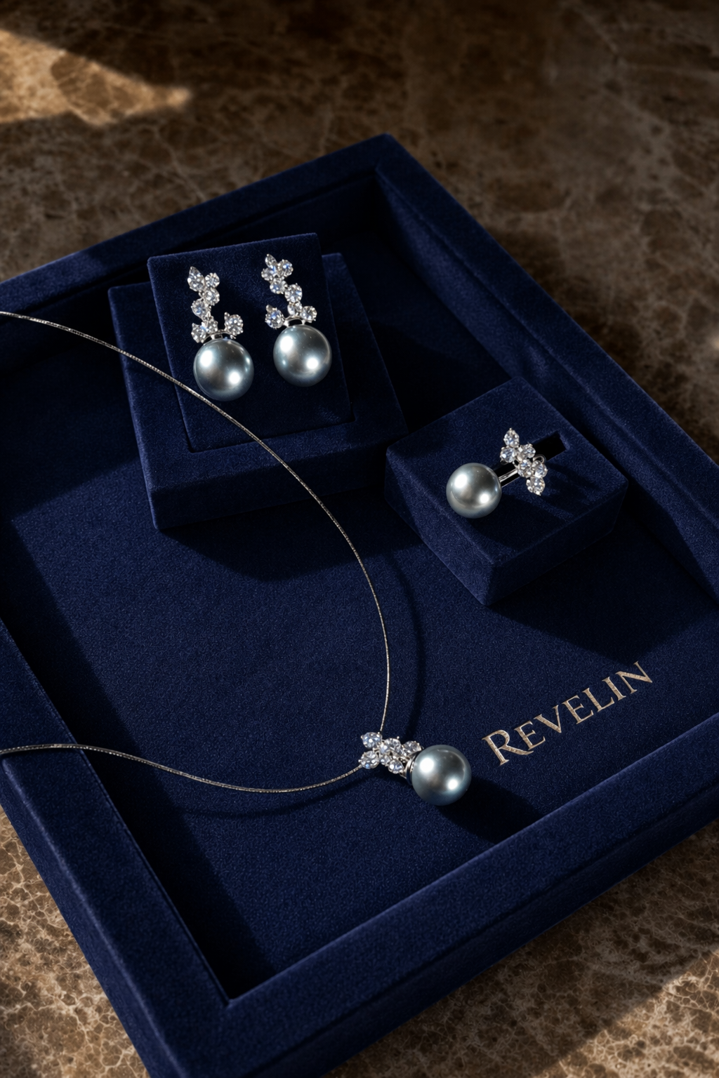 Revelin pearl jewellery arranged in a navy velvet box
